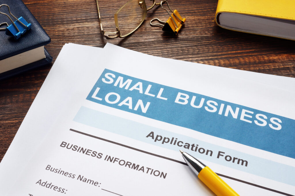 Small business loan application on the wooden surface and papers.