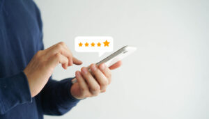 close up on customer hand pressing on smartphone screen with five star rating feedback icon and press level good rank for giving best score point to review the service
